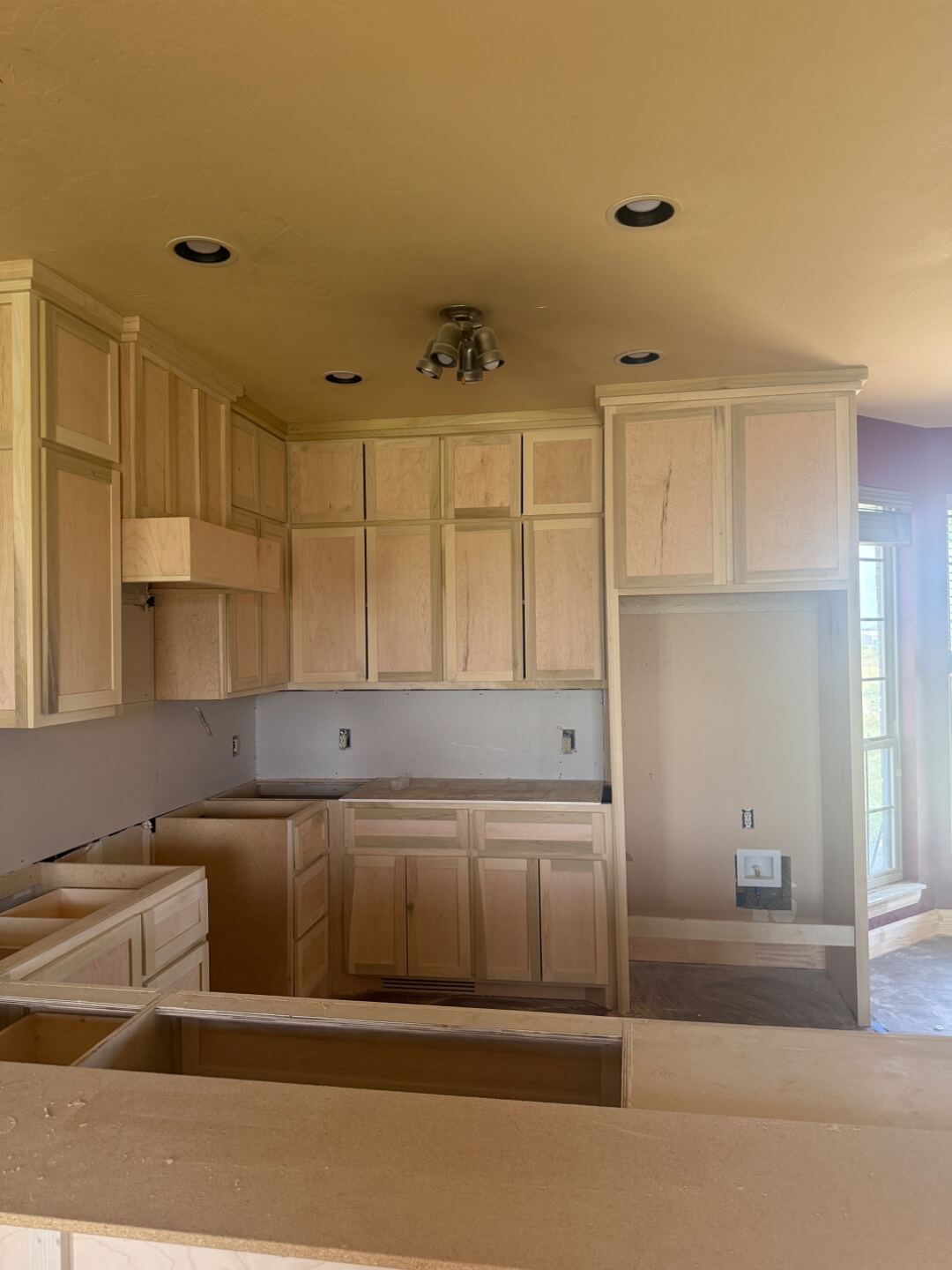 Second view of cabinet installation progress showing the island base going in.